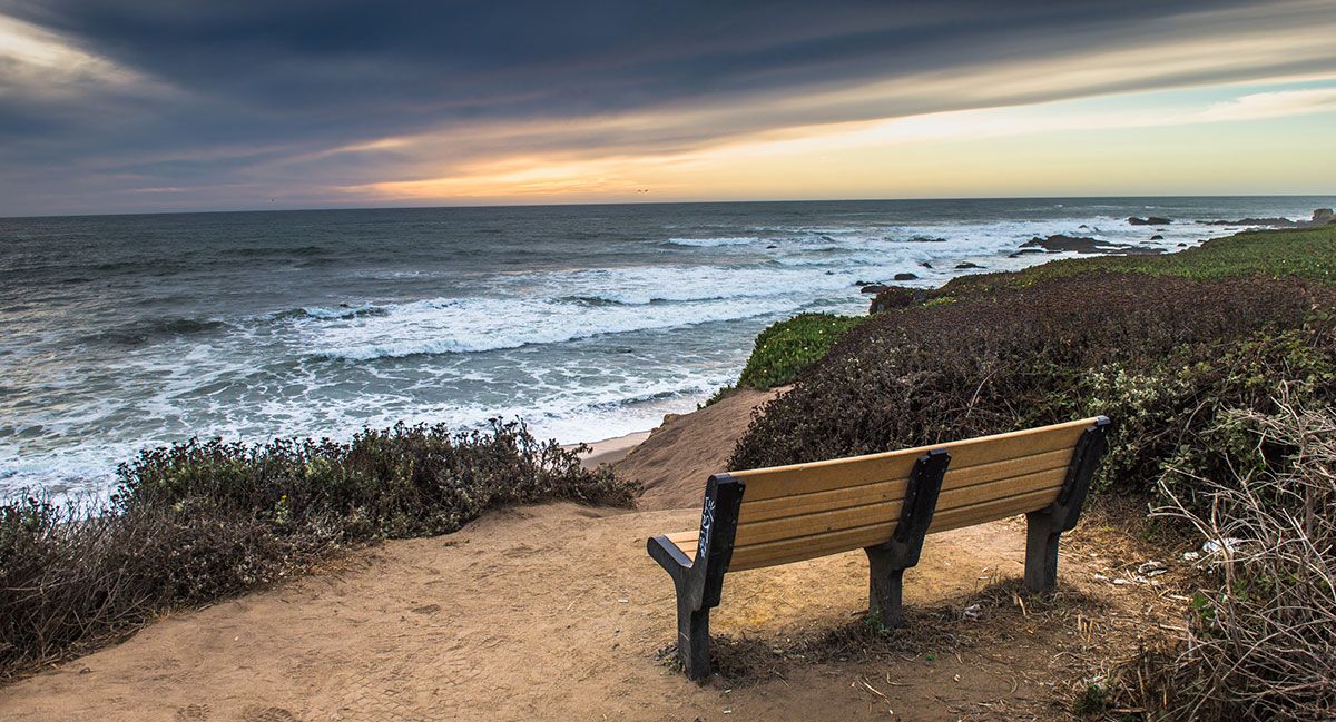 bench overlooking the pacific ocean at sunset